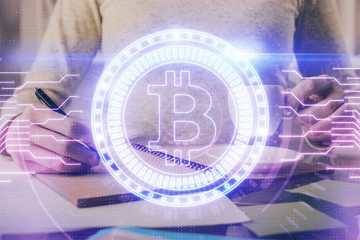Cryptocurrency hologram over woman's hands writing background. Concept of blockchain. Multi exposure