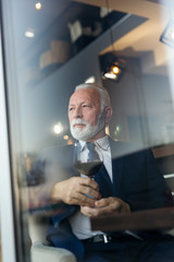 Senior businessman drinking wine in a restaurant