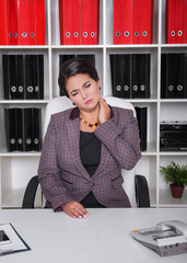 Business woman with pain in her neck in office