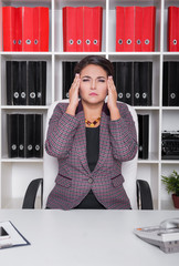 Business woman with pain in her head in office