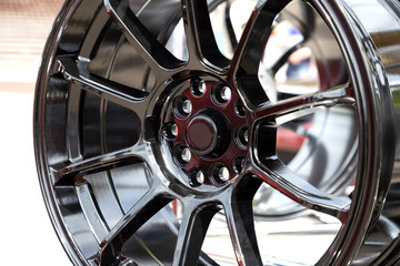 Modern metal alloy wheel for cars. Showcase with rims. Closeup view.