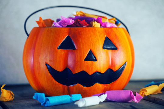 Pumpkin with candy on gray background for halloween party night.