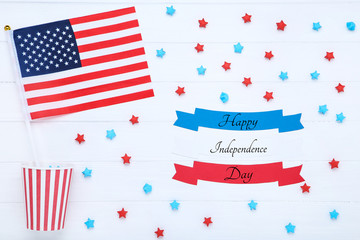 American flag with blank papers, stars and cup on white wooden table