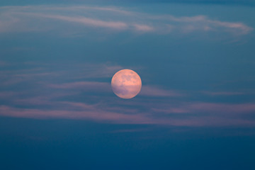 Full moon with colorful skies at sunset