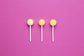 Yellow lollipops on crimson background