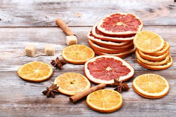 Dried citrus fruits with cinnamon, star anise and sugar cubes on brown wooden table