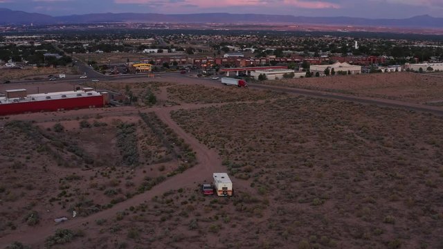 Drone crane aerial reveal shot of the Albuquerque New Mexico cityscape and residential areas with the backdrop of the Sandia Mountains.
