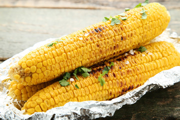 Grilled corn with green parsley on wooden table