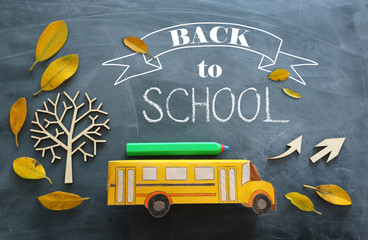 education and back to school concept. Top view photo of cardboard school bus and pencil next to...