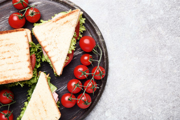 Tasty sandwiches with vegetables on brown cutting board