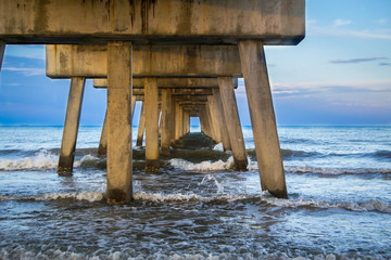 Crashing waves under fishing pier