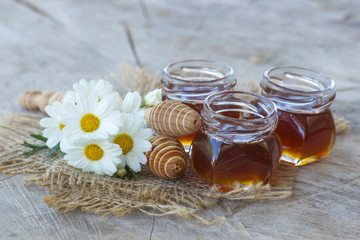 honey and flowers on wooden  background