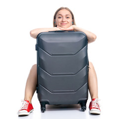 Woman with travel suitcase sitting waiting smiling on white background isolation