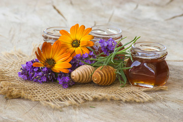 honey and flowers on wooden  background