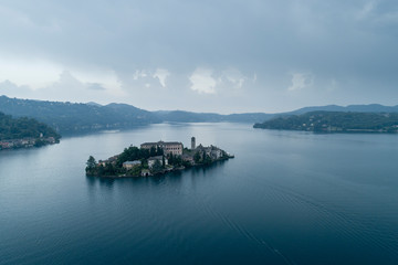 San Giulio island on Lake Orta (Piedmont, Italy) at evening. Aerial view. Italian landscape.