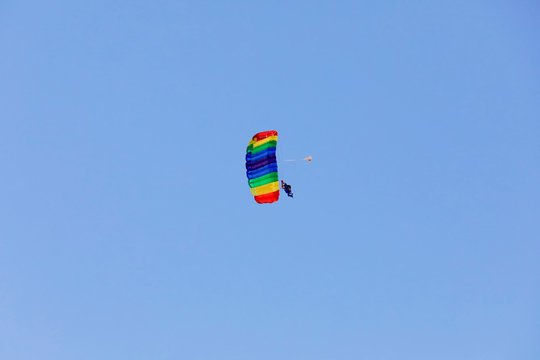 Paragleiter fliegt Figuren im blauen Himmel im Tandemsprung