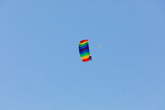 Paragleiter fliegt Figuren im blauen Himmel im Tandemsprung