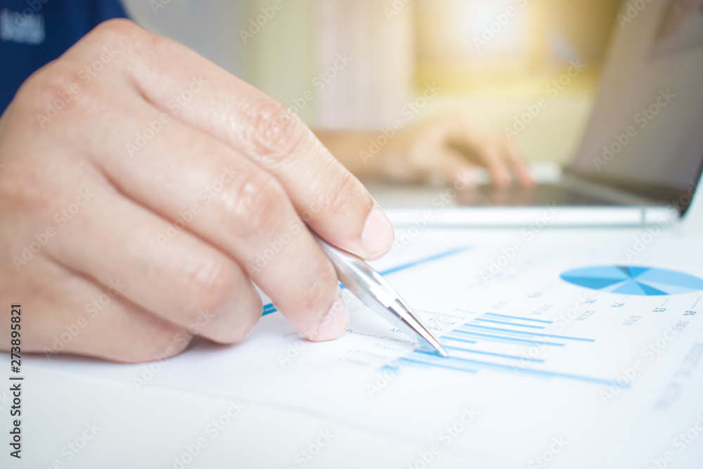 Poster close-up to the hands of businessmen working on the desk using computer desktops to calculate number