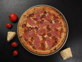 Pizza with sausage, sausages and cheese on a plate
