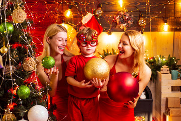 Christmas party. Women red dresses celebrate christmas with little cute baby. Family bonds. Love peace joy. Kid boy with mom or aunts sisters having fun. Join celebration. Christmas family fun