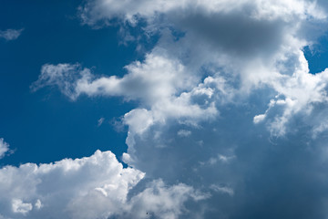 Naklejka na ściany i meble Luminous clouds set against a dark blue sky in the sun. Wonderful blue glowing cloud