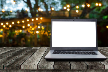 laptop notebook computer with white blank screen on desk with night light bokeh of night festival in garden, advertisement, workspace, internet technology, online social media, searching data concept
