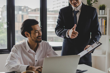 Good job man. business Boss team leader encourage and showing thumbs up expressing positive successful to young man employee in meeting room at home office company, encouragement and teamwork concept
