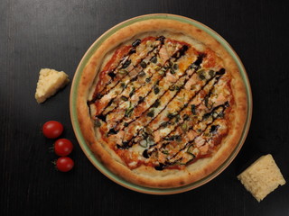 Pizza with salmon, onions and cheese on a plate