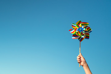 Child holds colorful pinwheel