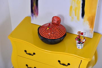 yellow comode with colorful decoration