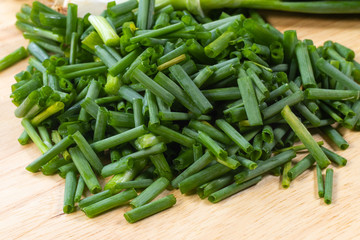 chopped of fresh scallion or spring onions on wooden board