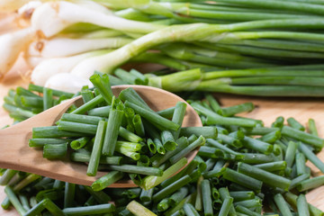 chopped of fresh scallion or spring onions on wooden board