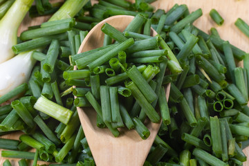 chopped of fresh scallion or spring onions on wooden board