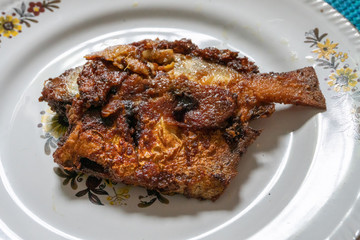 Fried pomfret fish served on a platter,