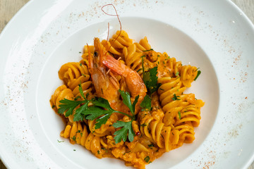 close up of prawn seafood fusilli pasta in a white plate