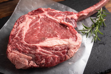 tomahawk ribeye steak on black stone plate