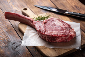 tomahawk ribeye steak on wooden cutting board