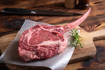 tomahawk ribeye steak on wooden cutting board