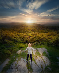 Senior woman facing the sun at sunset