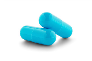 Two medical pills on white isolated background with shadow.