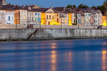 Arles. City embankment and facades of old houses at sunset.