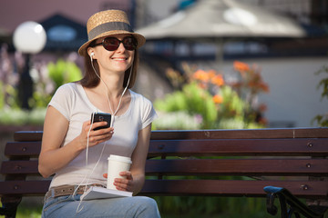 Charming young brunette sitting on a bench