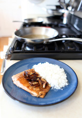 Plate of steelhead trout with chopped garlic and rice.