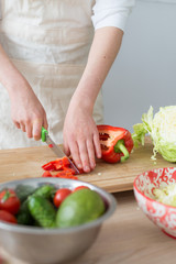 A woman makes a salad of fresh vegetables. Vegetarian, healthy food.
