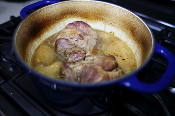 Pork roast cooked in a Dutch oven resting on the stove top.