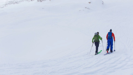 Ski resort. Two people walking upwards by the ski in a mountains