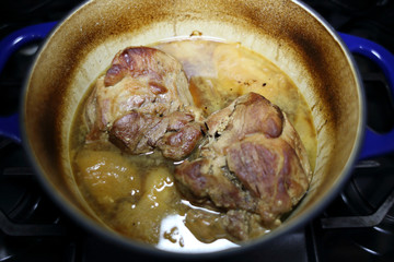 Pork roast cooked in a Dutch oven resting on the stove top.