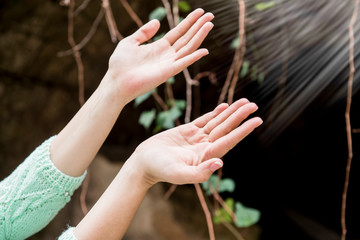 Female hands reach for sacred light in the sky, hope for rescue