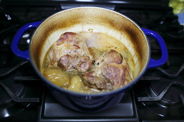 Pork roast cooked in a Dutch oven resting on the stove top.
