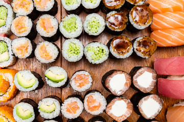 various sushi and rolls on wooden table